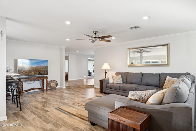 living room featuring light wood-type flooring, ceiling fan, and crown molding