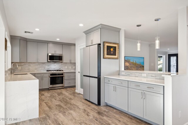 kitchen featuring gray cabinets, sink, light wood-type flooring, and appliances with stainless steel finishes