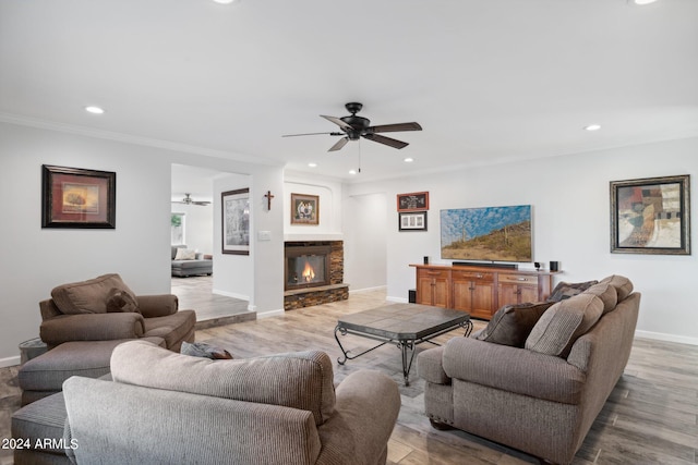 living room with light wood-type flooring, ceiling fan, and crown molding