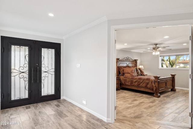 foyer entrance with french doors, light hardwood / wood-style floors, ceiling fan, and ornamental molding