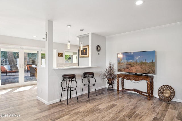 kitchen featuring hardwood / wood-style flooring, decorative light fixtures, and crown molding