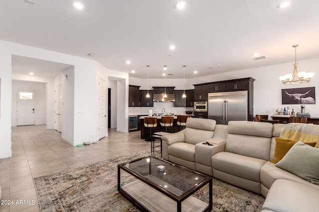 tiled living room with wine cooler, sink, and an inviting chandelier