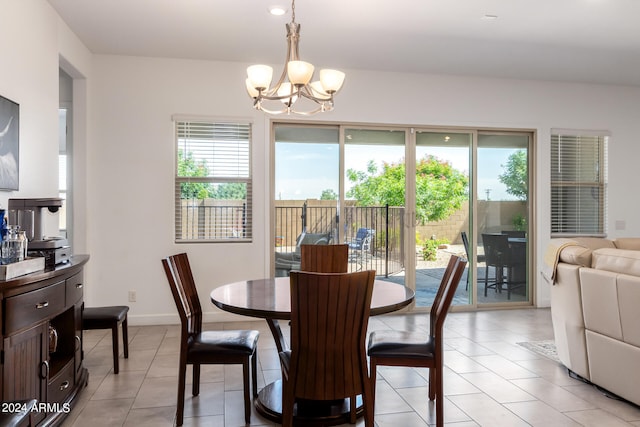 dining area with a healthy amount of sunlight, light tile flooring, and a chandelier