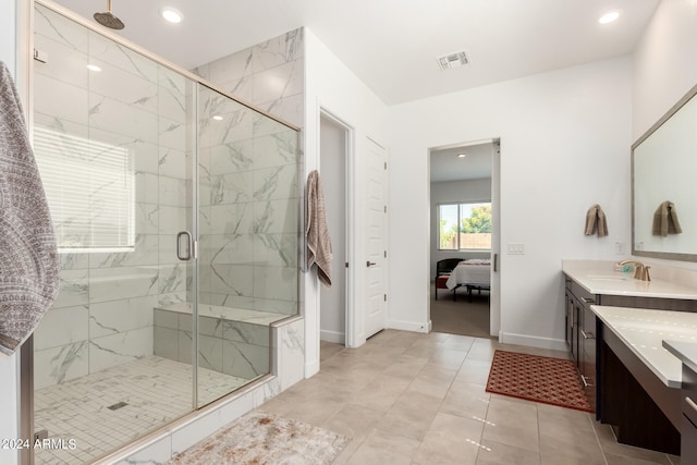 bathroom with tile floors, walk in shower, and double vanity