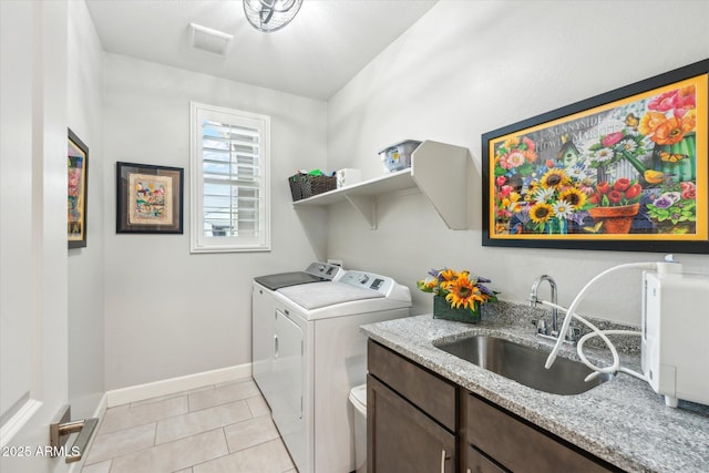 laundry room with visible vents, baseboards, light tile patterned floors, washer and dryer, and a sink