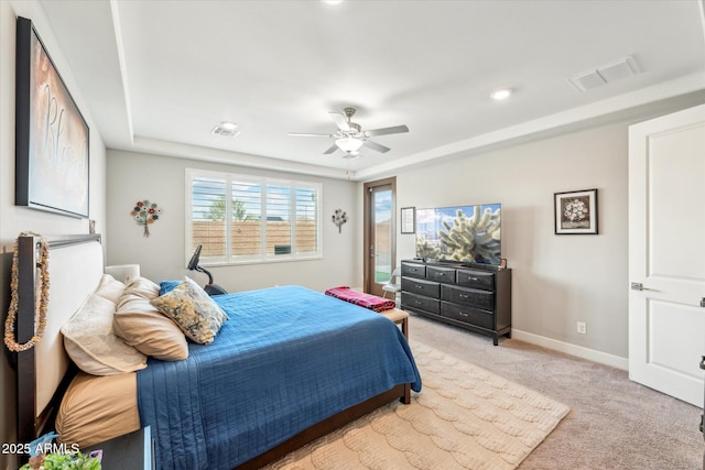 bedroom featuring light carpet, visible vents, a tray ceiling, and baseboards