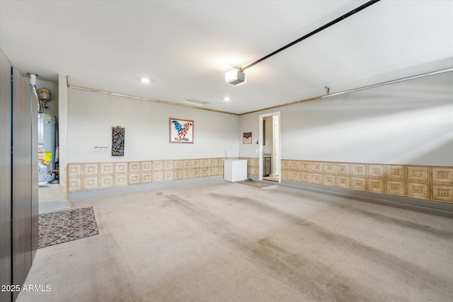 garage with a garage door opener, water heater, recessed lighting, wallpapered walls, and baseboards