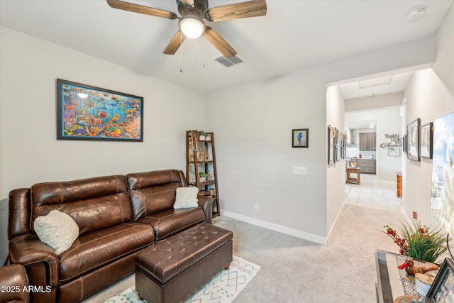 living area with visible vents, light carpet, baseboards, and ceiling fan