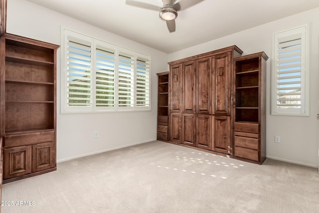 unfurnished bedroom featuring a ceiling fan, light colored carpet, and baseboards