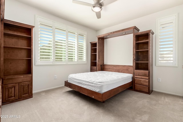 carpeted bedroom with ceiling fan and baseboards