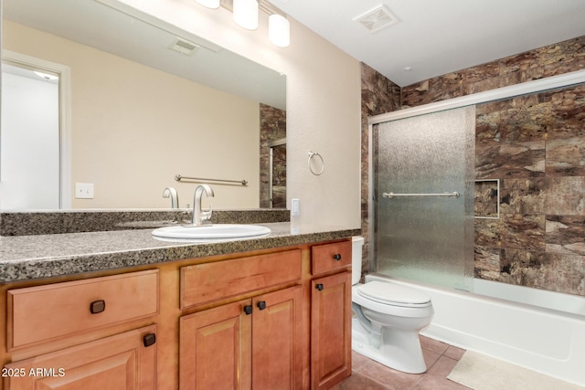 bathroom featuring enclosed tub / shower combo, toilet, visible vents, vanity, and tile patterned floors