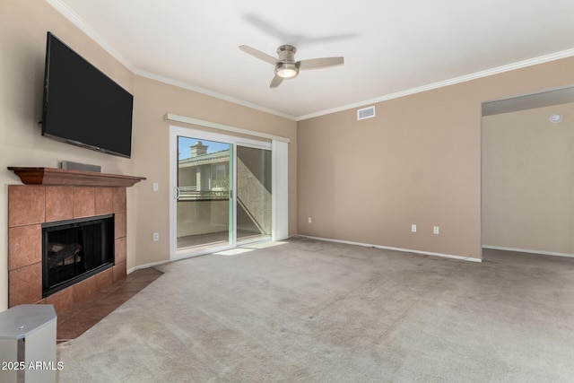 unfurnished living room with carpet, crown molding, visible vents, a tiled fireplace, and ceiling fan