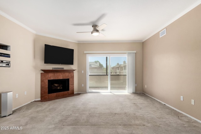 unfurnished living room with carpet floors, a fireplace, visible vents, and ornamental molding