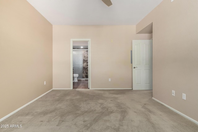 unfurnished bedroom with carpet floors, baseboards, and ensuite bathroom