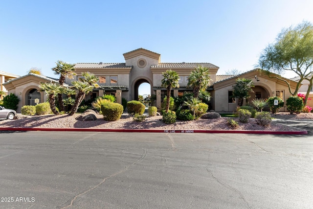 mediterranean / spanish-style home featuring a tiled roof and stucco siding