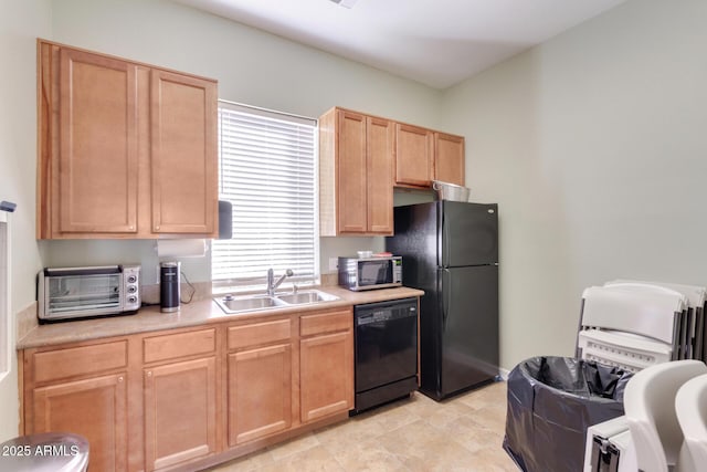 kitchen with a toaster, a sink, light countertops, light brown cabinetry, and black appliances