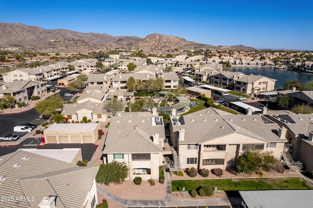 drone / aerial view featuring a water and mountain view and a residential view