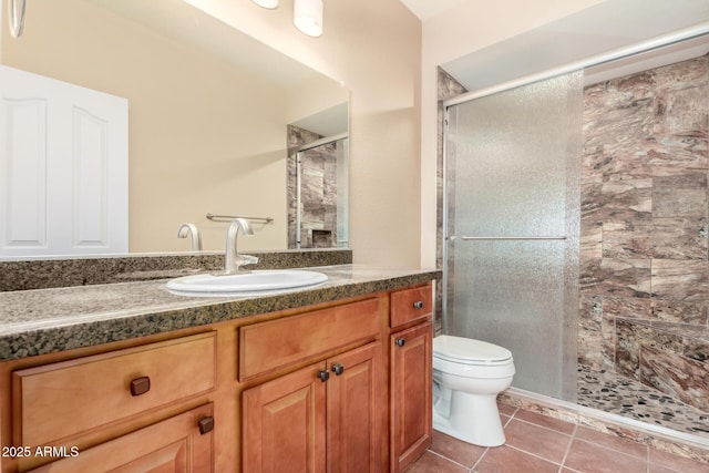 full bath featuring a stall shower, vanity, toilet, and tile patterned floors