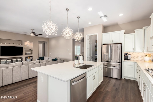 kitchen featuring appliances with stainless steel finishes, a sink, ceiling fan, a chandelier, and dark wood-type flooring