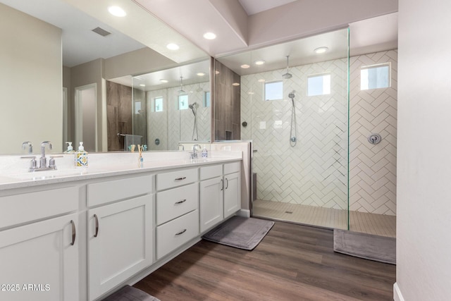 bathroom featuring a shower stall, double vanity, plenty of natural light, and recessed lighting