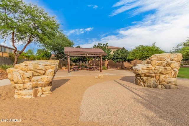 surrounding community featuring a gazebo, fence, and a patio area