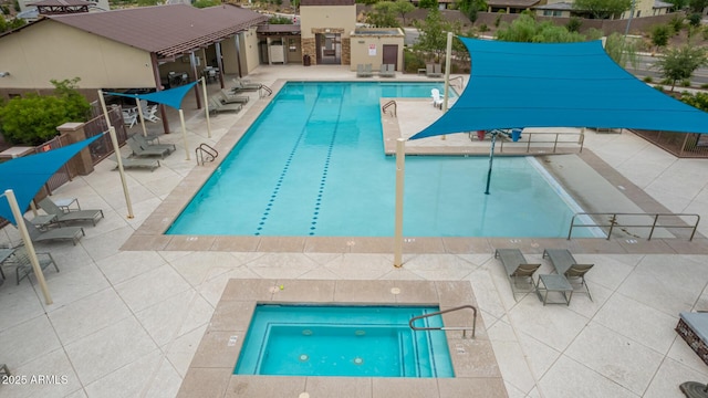 community pool with a patio and fence