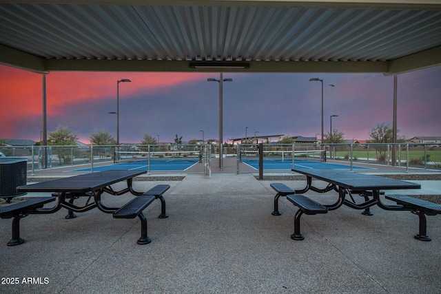 surrounding community with a tennis court and fence