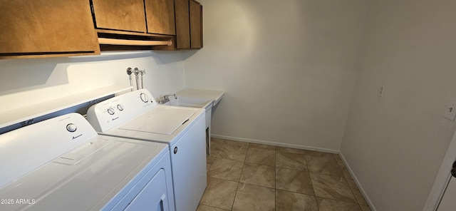 laundry area featuring separate washer and dryer, light tile patterned floors, and cabinets