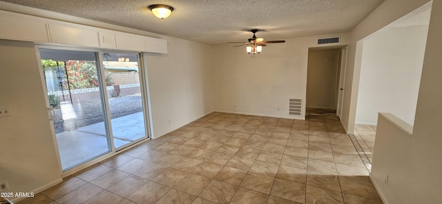 empty room featuring ceiling fan, a textured ceiling, and light tile patterned floors