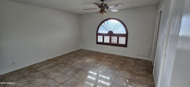 unfurnished room featuring ceiling fan and a textured ceiling