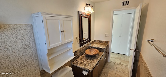 bathroom with tile patterned flooring, vanity, and toilet