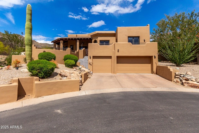 13554 E Columbine Dr, Scottsdale, AZ 85259 - pueblo-style home with an attached garage, concrete driveway, and stucco siding