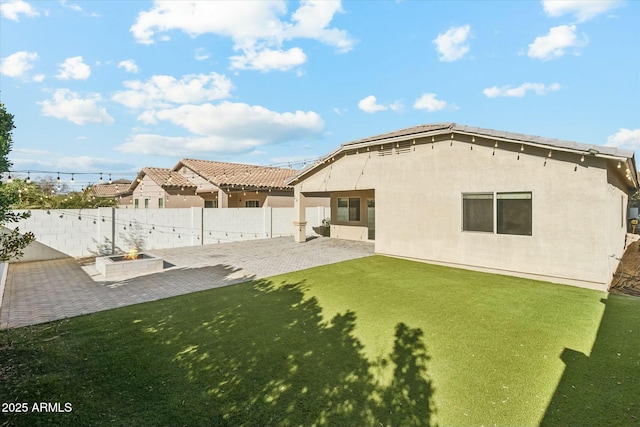 back of house featuring a patio area and a lawn