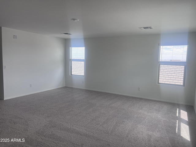 empty room with baseboards, carpet flooring, and visible vents