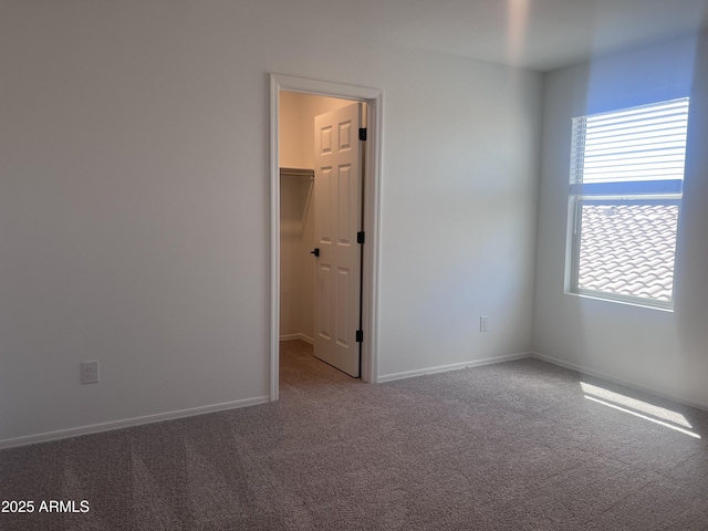 empty room with baseboards and carpet flooring