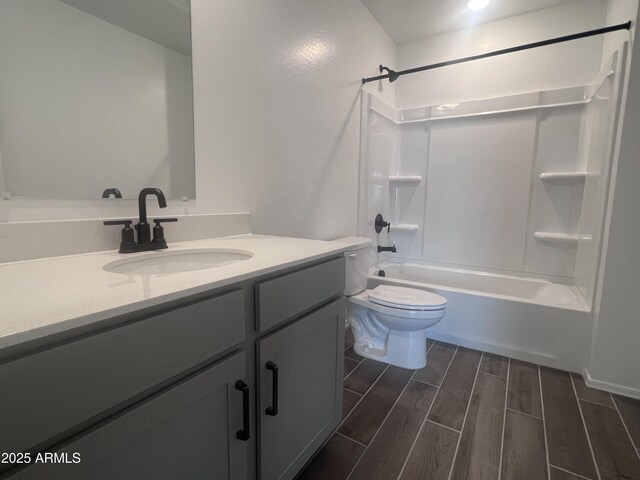 full bathroom with wood finished floors, tub / shower combination, vanity, and toilet