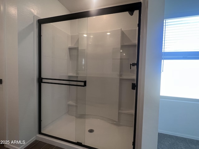 full bath featuring a shower stall and baseboards