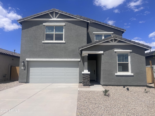 view of front of home with a garage, a tiled roof, concrete driveway, and stucco siding