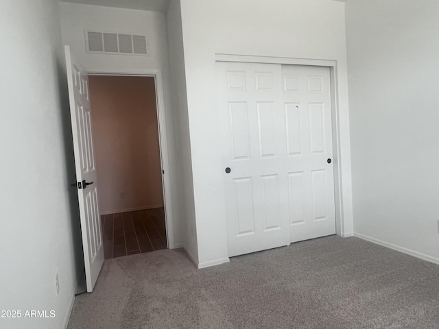 unfurnished bedroom featuring a closet, visible vents, carpet flooring, and baseboards
