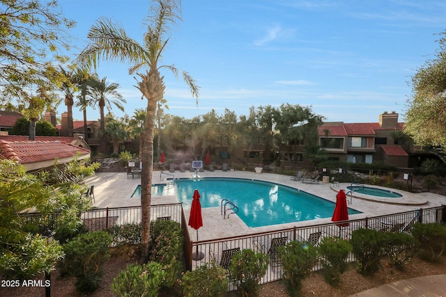 pool with a community hot tub, a patio area, and fence