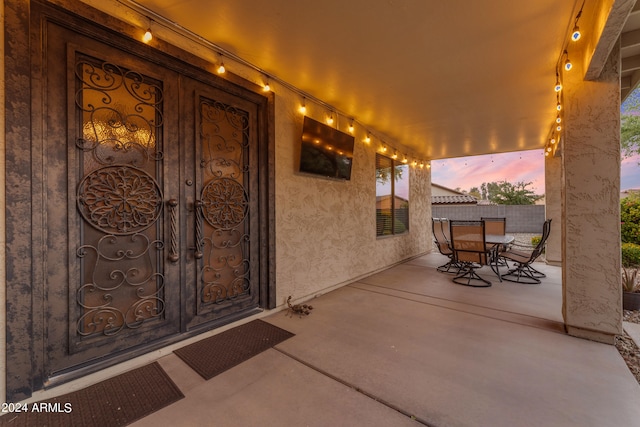 view of exterior entry featuring a patio area