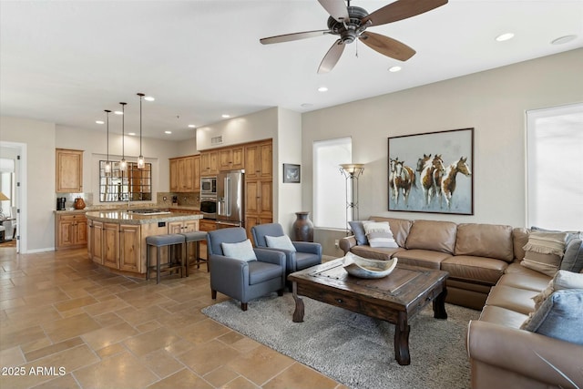 living room featuring recessed lighting, baseboards, a ceiling fan, and stone finish floor