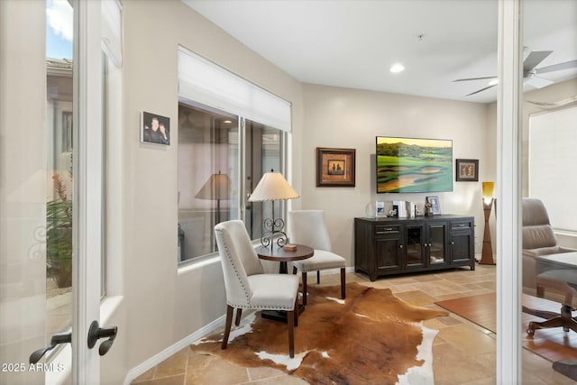 living area with stone tile floors, recessed lighting, a ceiling fan, and baseboards