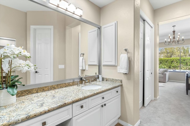 bathroom featuring vanity, baseboards, and a chandelier