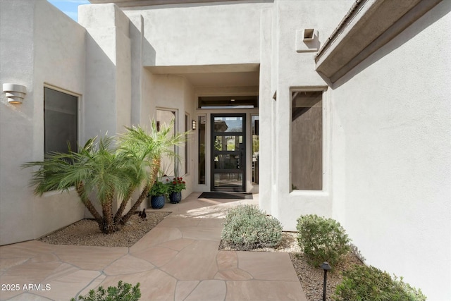 view of exterior entry featuring stucco siding