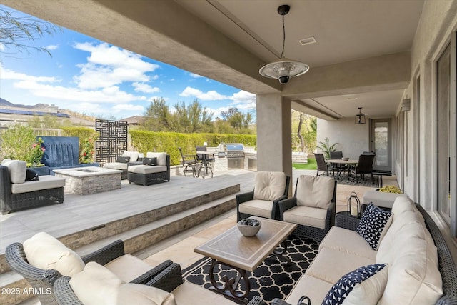 view of patio with an outdoor living space with a fire pit, exterior kitchen, outdoor dining area, and a grill