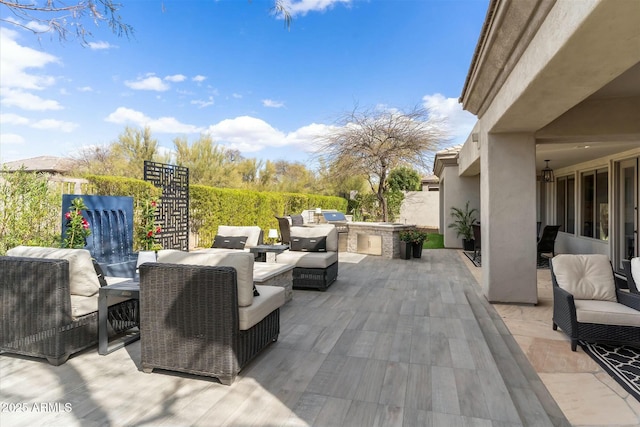 view of patio featuring exterior kitchen, fence, and an outdoor hangout area