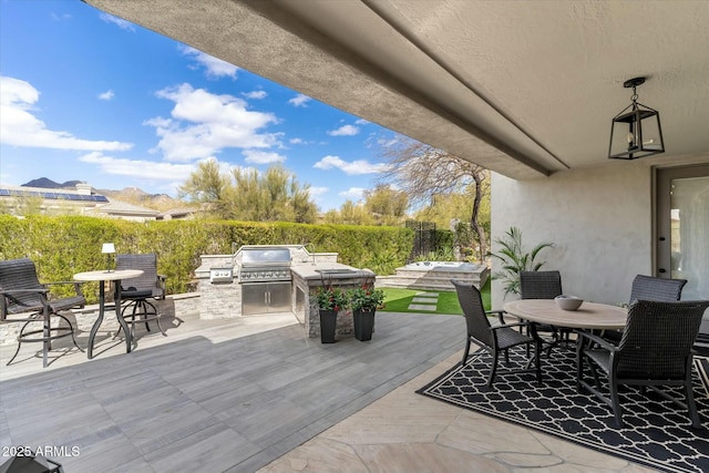 view of patio / terrace featuring an outdoor kitchen, a grill, outdoor dining area, and fence