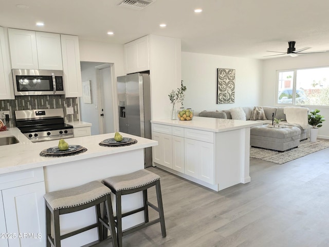 1561 N Sterling St, Mesa, AZ 85207 - kitchen featuring appliances with stainless steel finishes, a peninsula, white cabinets, and recessed lighting