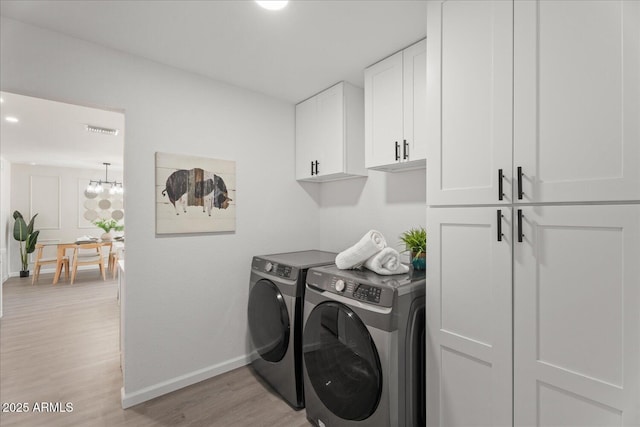 1561 N Sterling St, Mesa, AZ 85207 - washroom featuring washing machine and clothes dryer, cabinet space, light wood-type flooring, and a chandelier